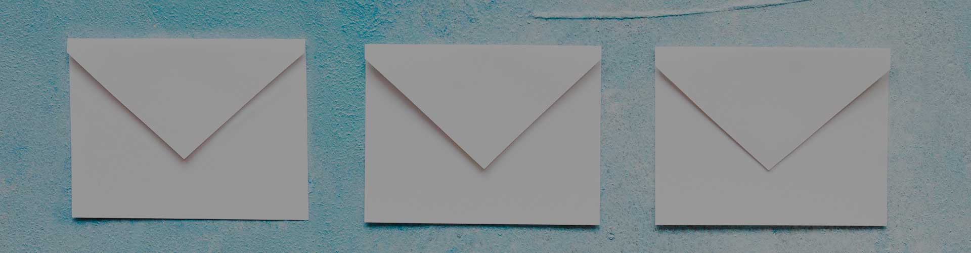 three closed envelopes on a blue painted background
